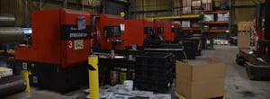 Red industrial-grade saws in a dedicated warehouse sawing area