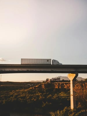 White freight truck driving on a scenic overpass